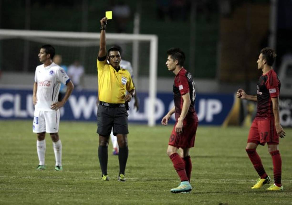 El árbitro guatemalteco Walter López le muestra tarjeta amarilla a Jorge Villafaña.