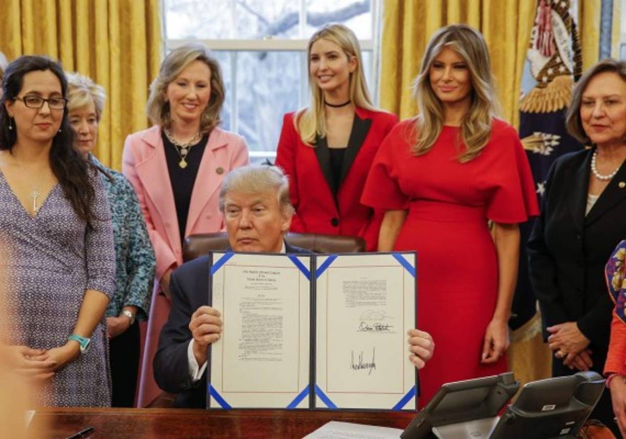 ELX01. WASHINGTON (EE.UU.), 28/02/2017.- El presidente de EE.UU. Donald J. Trump (c) muestra la Resolución 321 hoy, martes 28 de febrero de 2017, durante un acto donde firmo dos resoluciones para destacar en las mujeres y jóvenes el estudio y la búsqueda de sus carreras en ciencia, tecnología, ingeniería y matemáticas (STEM), en la Oficina Oval de la Casa Blanca en Washington (EE.UU.). Trump estuvo acompañado por la primera dama Melania Trump (2.d) y su hija Ivanka (c-atrás). EPA/ERIK S. LESSER