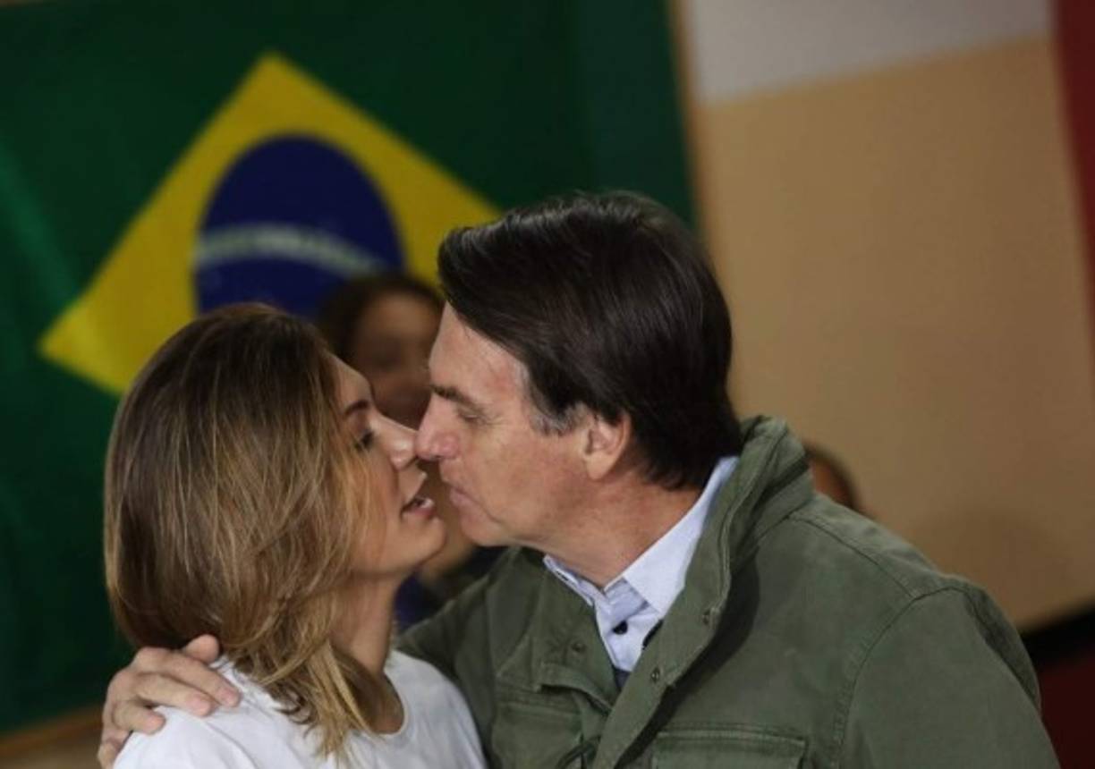 Jair Bolsonaro, far-right lawmaker and presidential candidate of the Social Liberal Party (PSL), and his wife Michelle kiss before casting their votes, in Rio de Janeiro, Brazil October 28, 2018 (Photo by RICARDO MORAES / POOL / AFP)