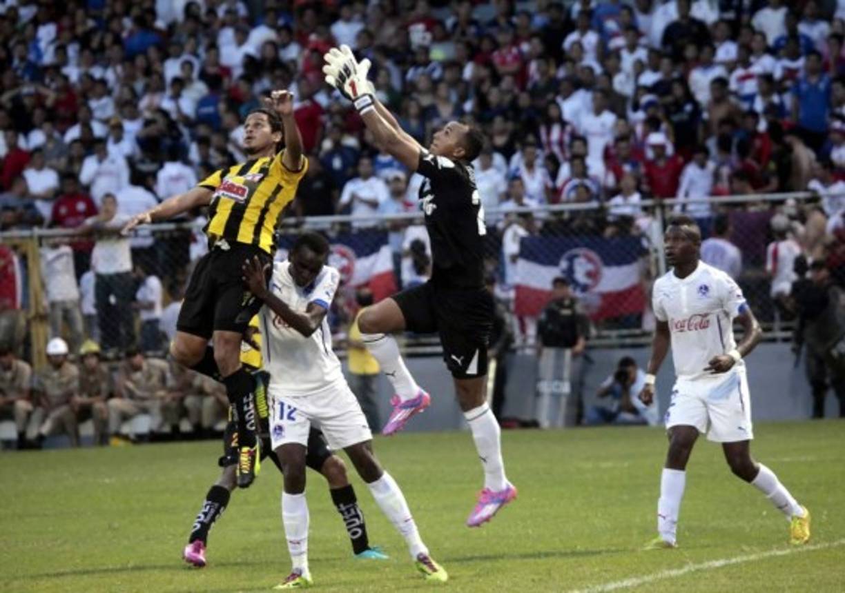 El guardameta albo Donis Escober salta para quedarse con el balón.