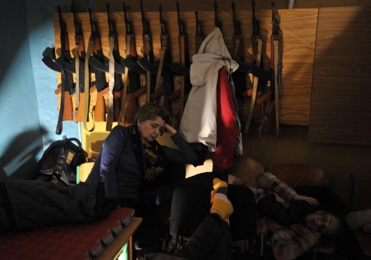 Pese al ruido de las sirenas, algunos tratan de dormir en colchones en el suelo, otros se quedan charlando. 