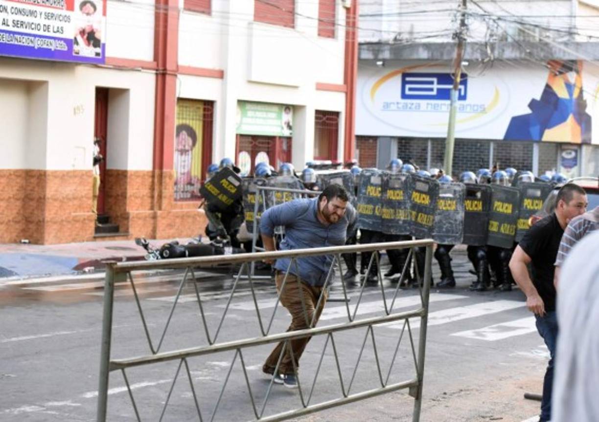 Agentes antidisturbios que acordonan el edificio, en el centro de Asunción, dispararon balines de goma a manifestantes.<br/>