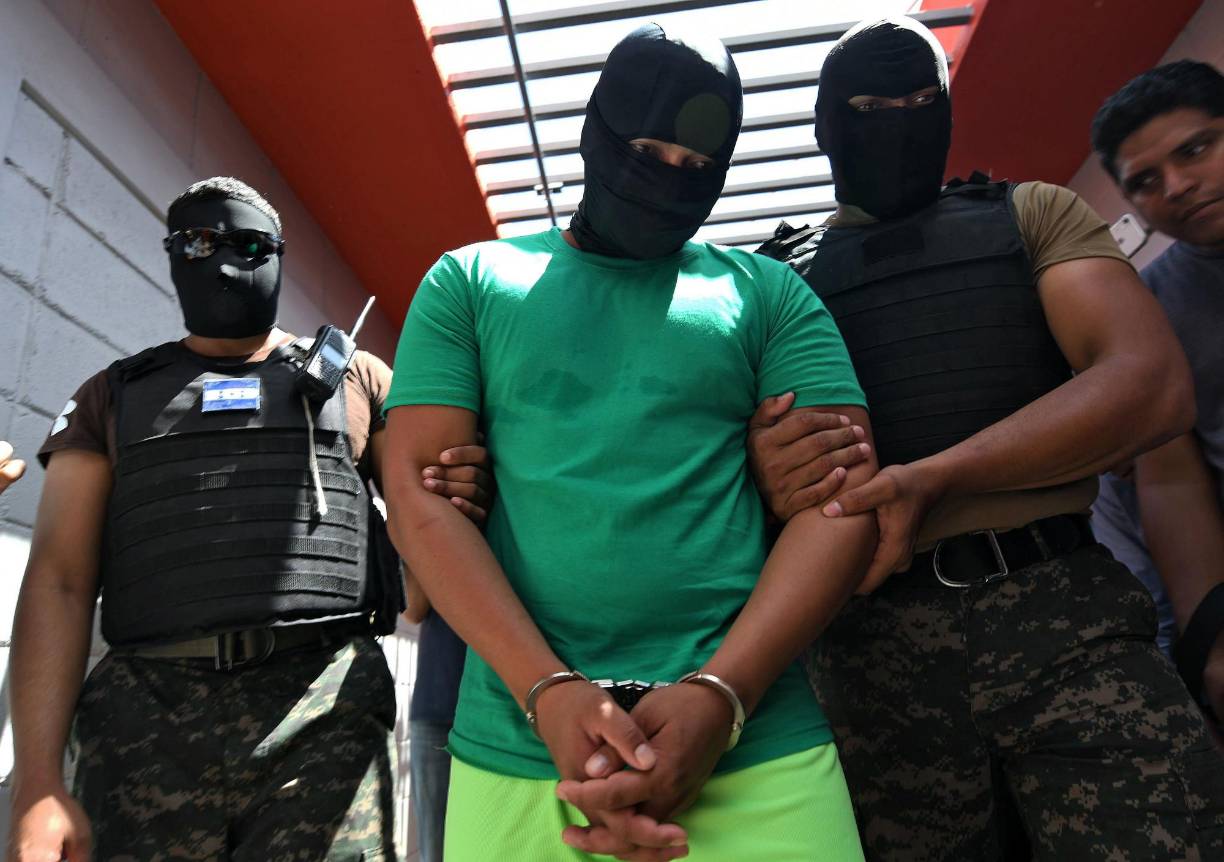 An inmate is escorted by Military Police officers to La Jaula, a maximum security unit at Tamara National Penitentiary, in Tamara, Francisco Morazan Department, just north of Tegucigalpa, on October 7, 2019. - La Jaula was converted into a maximum security unit to hold some of the most dangerous criminals in Honduras, including leaders of the Barrio 18 and MS-13 gangs and extortionists. (Photo by Orlando SIERRA / AFP)