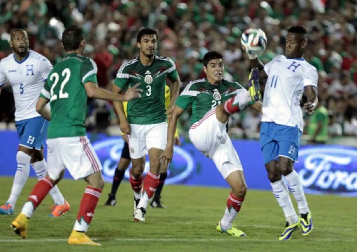 Enrique Pérez intenta patearle el balón a Romell Quioto.