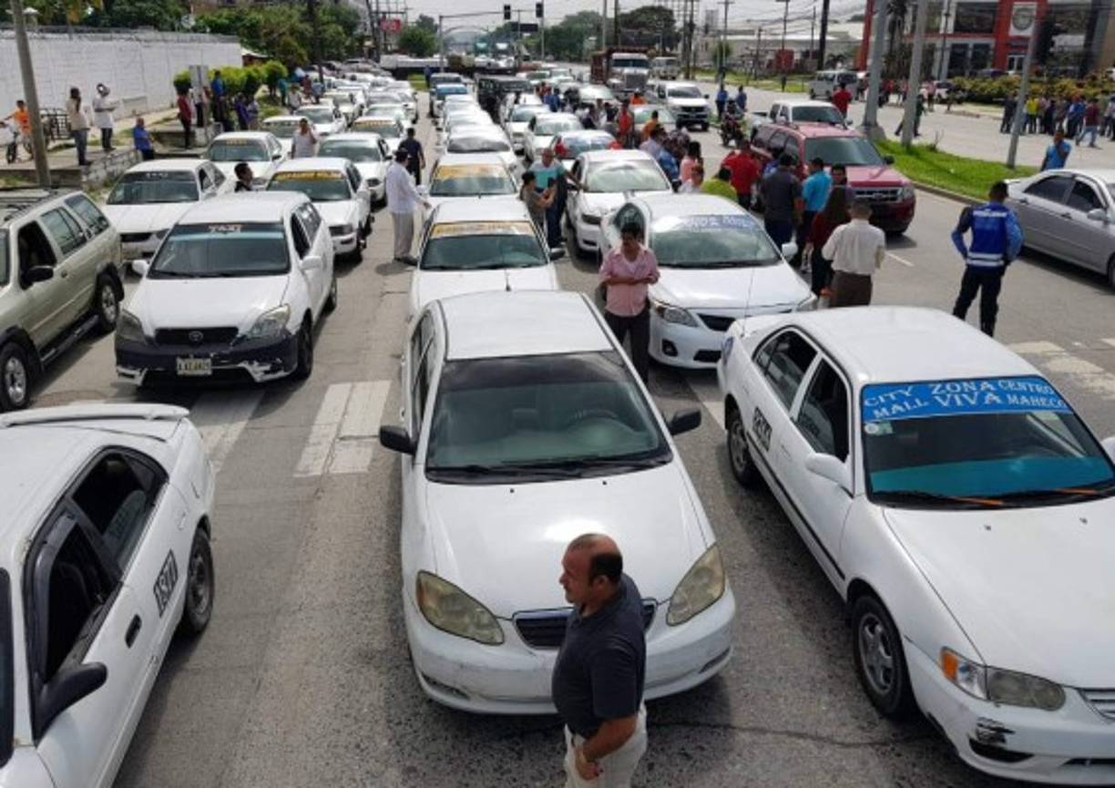 Conductores de taxis parquean sus unidades en una vía en el bulevar del norte de San Pedro Sula.