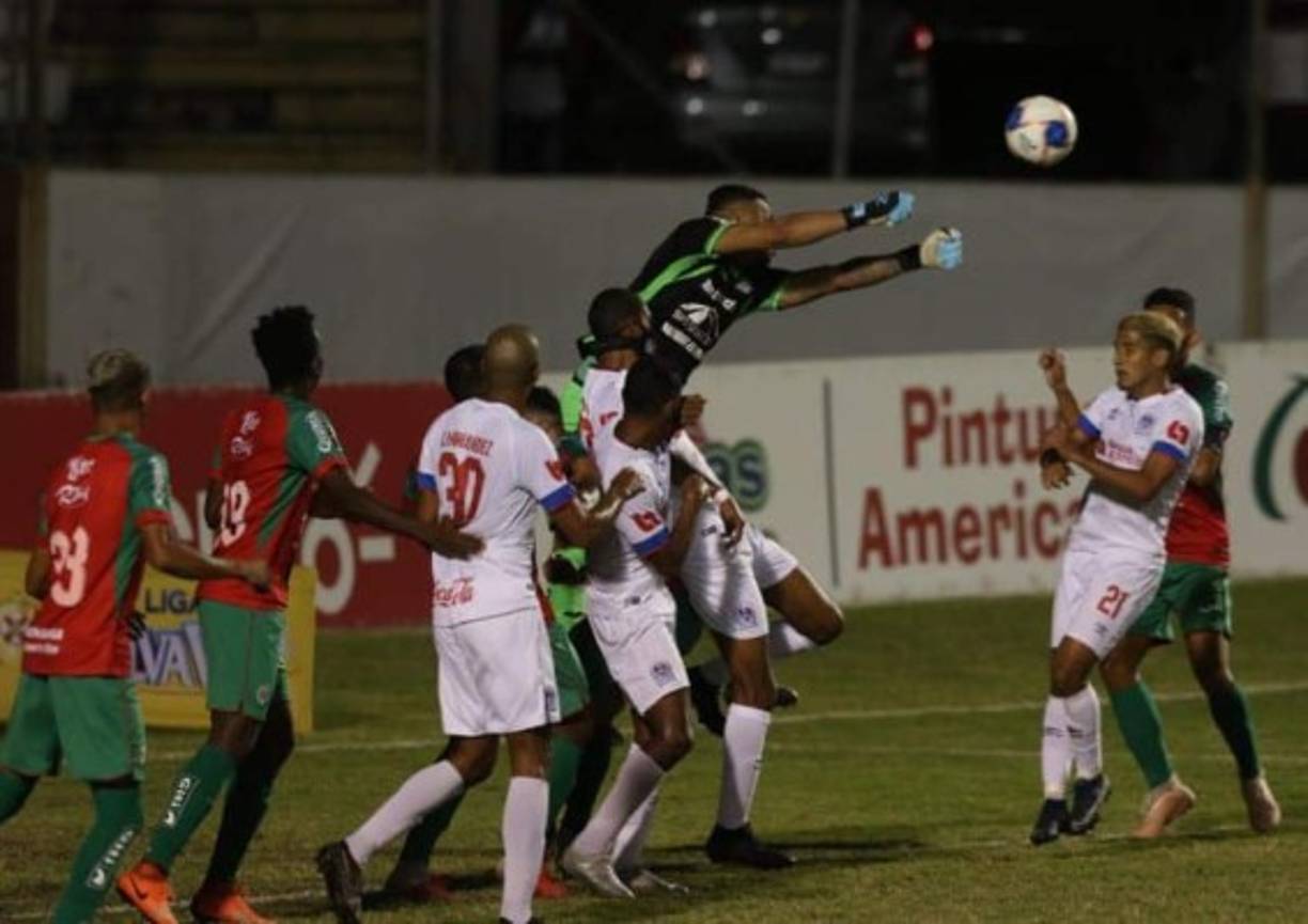 Denovan Torres despejando de puños un balón en su área.