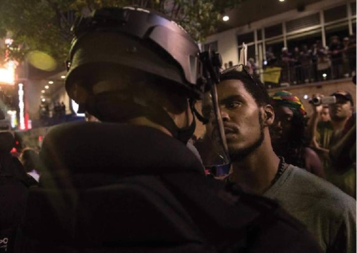 Estados Unidos. Confrontación racial. Un manifestante se enfrenta a un policía en una protesta contra la brutalidad policial en Charlotte, Carolina del Norte, el 21 de septiembre de 2016, luego de que el afroamericano Keith Lamont Scott muriera abatido por la policía.