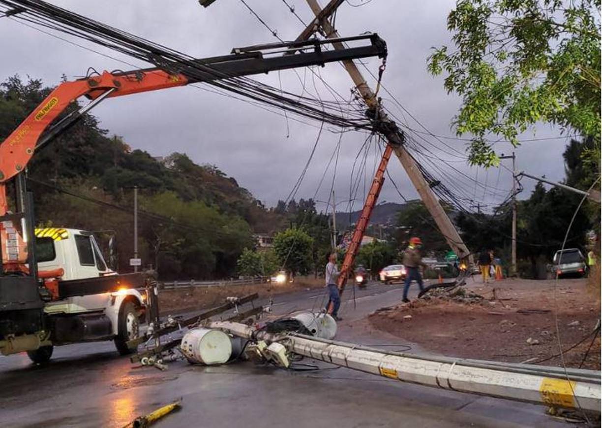 Una cuadrilla de la Enee trabaja en el anillo periférico de Tegucigalpa para restablecer el servicio eléctrico tras la destrucción de un poste en un accidente vehicular. 
