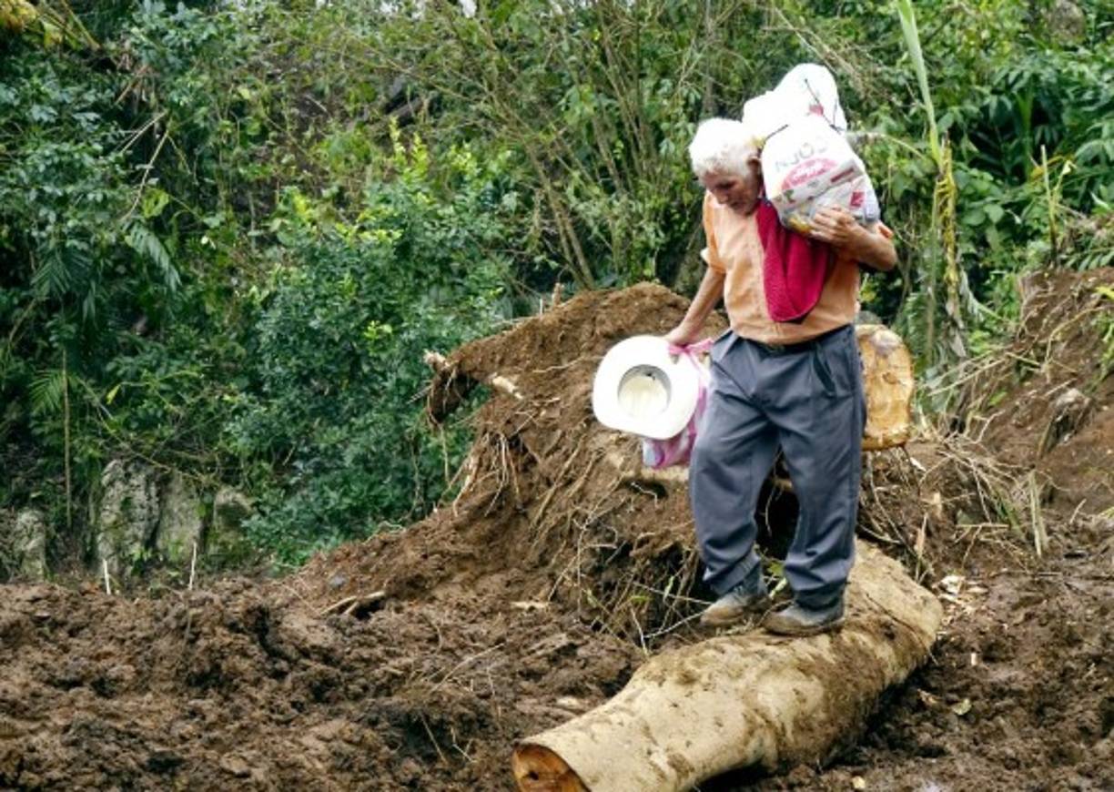 En Zapote Injerto quedaron viviendas que penden de un hilo para ser tragadas por los derrumbes y otras que están en los alrededores están vacías.Lucio Rodríguez, otro de los pobladores albergado en la escuela de El Dorado, camina unos 20 minutos para ir a ver su casa en el Zapote Injerto, la cual está en la zona del derrumbe y sabe que no puede regresar a habitarla.<br/><br/>“No sabemos qué harán con nosotros, es lo único que tenemos en esta zona, sigo haciendo unos trabajos, pero es difícil no tener donde vivir”, expresó.Estando en la zona de derrumbe, periodistas de LA PRENSA se encontraron con un grupo de habitantes que venían de otra aldea de traer una provisión de comida que daban personas solidarias, pero solo eran 19 raciones y muchos regresaron con sus manos vacías.<br/><br/>Los pobladores deben caminar, porque después de Zapote Injerto no hay paso por la cantidad de tierra que aún hay en la calle y que sigue amenazando la comunidad.<br/><br/>Desolación.<br/><br/>