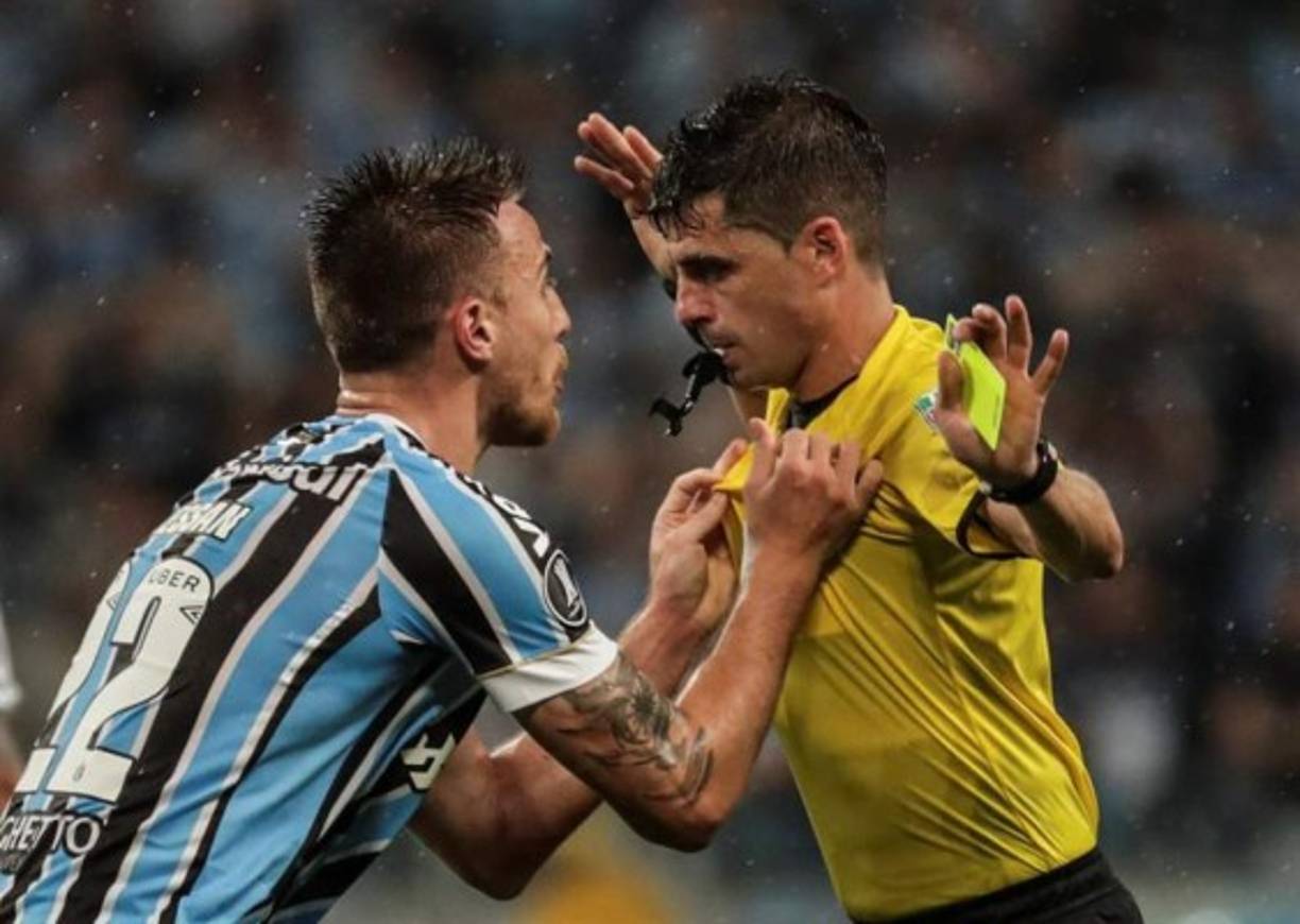 En la imagen, el jugador del Gremio, Matheus Simonete Bressanelli, más conocido como Bressan, se enfrenta al árbitro Andrés Cunha, luego que éste lo expulsara por desviar al tiro de esquina la pelota con la mano. En ese momento el River anotó el 2-1 y consiguió el pase a la final frente al Boca Juniors de Argentina. EFE