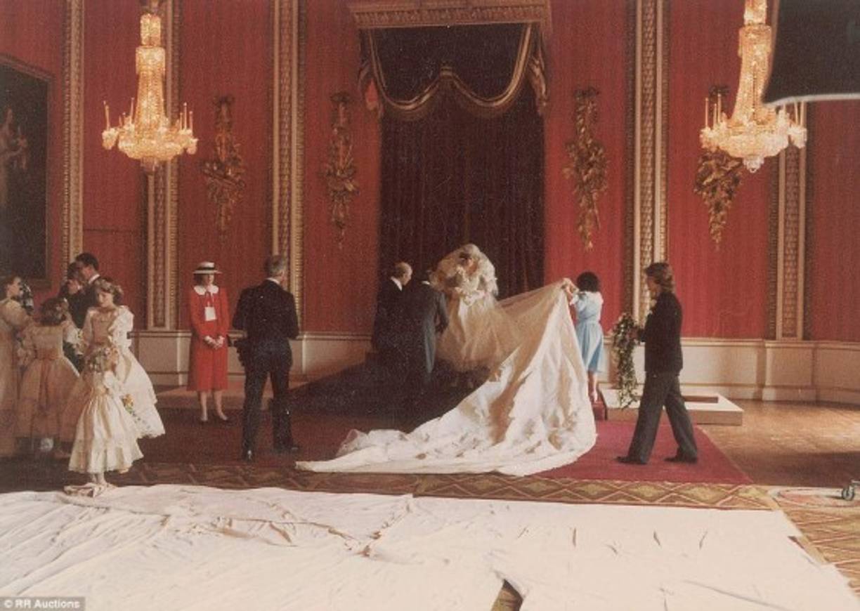Empleados del palacio ayudan con el vestido a la princesa Diana de Gales minutos antes de posar para la foto oficial de su boda con el príncipe Carlos de Inglaterra.