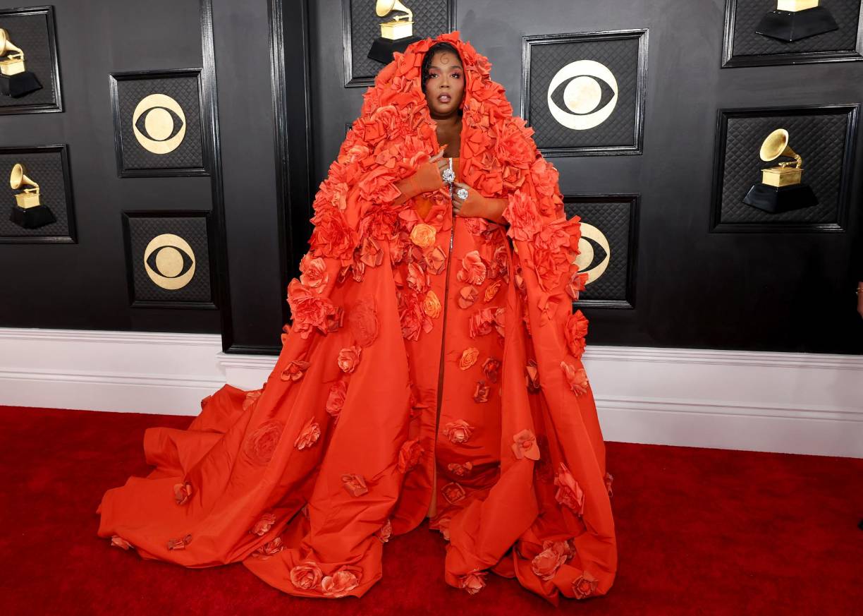 Lizzo pisó la alfombra roja con un vestido estilo corsé naranja con un abrigo cubierto de flores