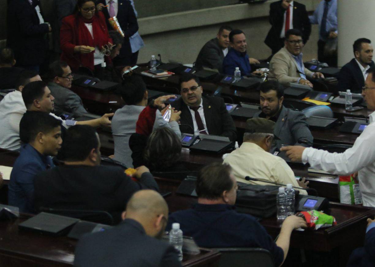 La bancada de Libre conversa mientras toman refresco y crurros.