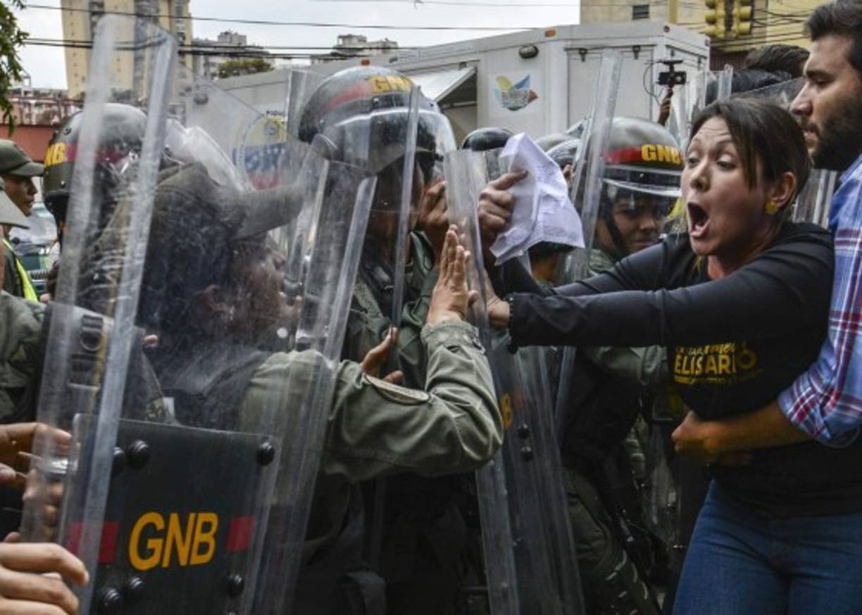Diputados opositores venezolanos protagonizaron este jueves una refriega con militares frente a la sede del Tribunal Supremo de Justicia (TSJ) en Caracas, adonde acudieron para rechazar una sentencia con la que esa corte asumió sus funciones.<br/>