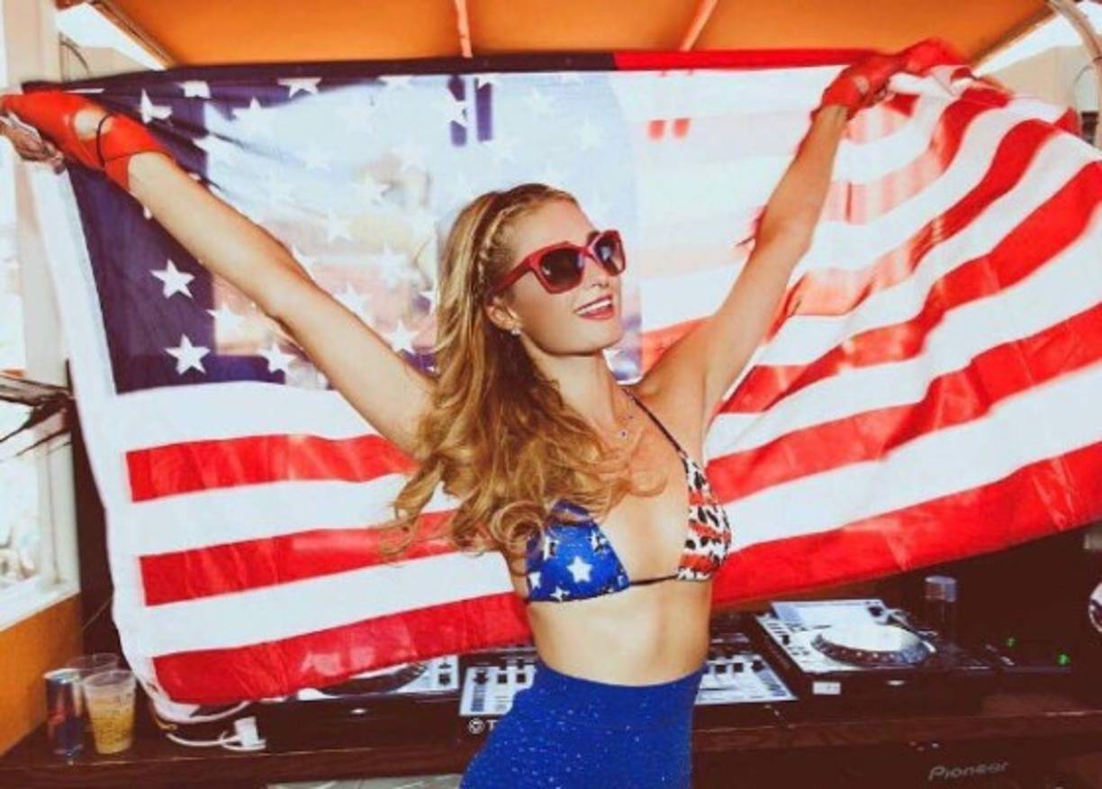 La socialité Paris Hilton fue una de las primeras celebridades en desear 'un feliz 4 de Julio' a sus miles de seguidores en Instagram, con una imagen patriótica en la que aparece con la bandera estadounidense mostrando su bikini de barras y estrellas.