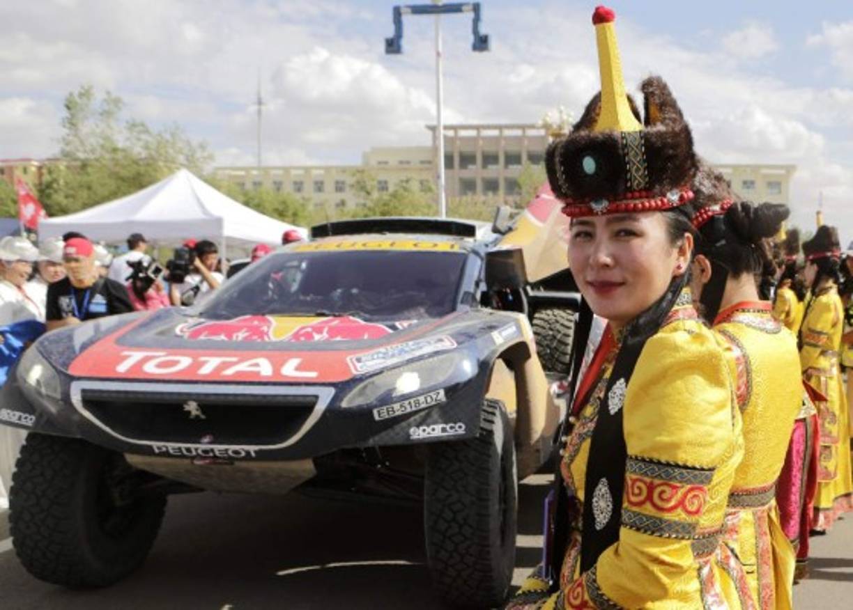 RALLY. Qué bienvenida. Las mujeres de Mongolia vestidas con su traje para darle la bienvenida al piloto del equipo Peugeot Sport, Stéphane Peterhansel, y Jean-Paul Cottret. Foto: AFP/Patrick Baz