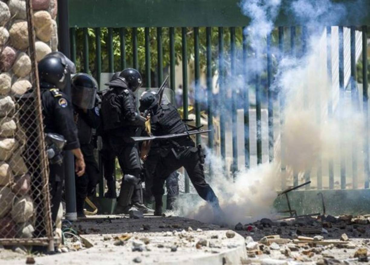 La policía arroja gases lacrimógenos contra los manifestantes.