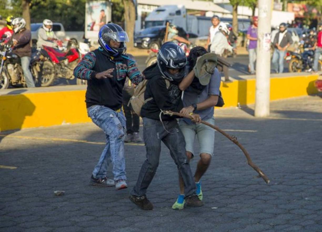 Los grupos de choque que interrumpieron las protestas, algunos luciendo camisas con logotipos gubernamentales y ocultando su rostros con cascos de motocicleta, comenzaron a golpear a los manifestantes, quienes huían y se refugiaban en negocios de comida aledaños.