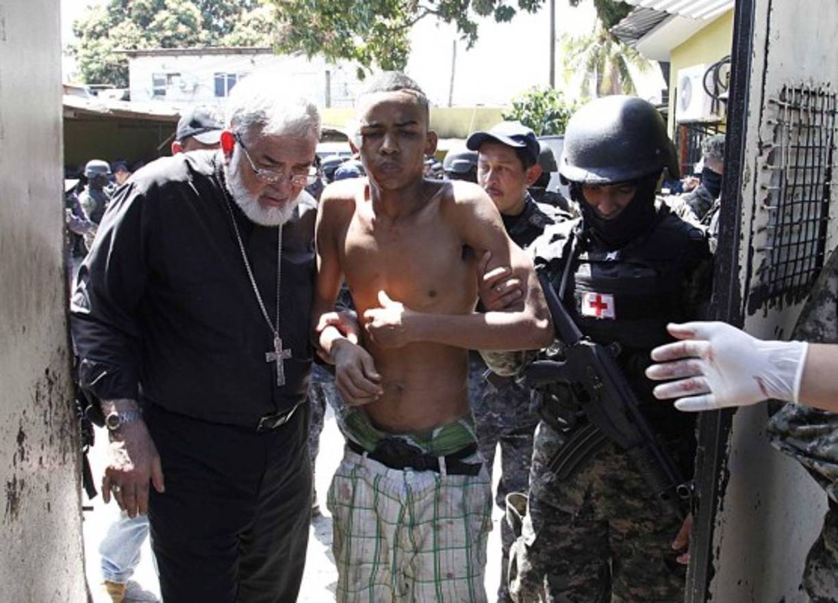 Monseñor Rómulo Emiliani en el momento en que auxilia a uno de los reclusos.