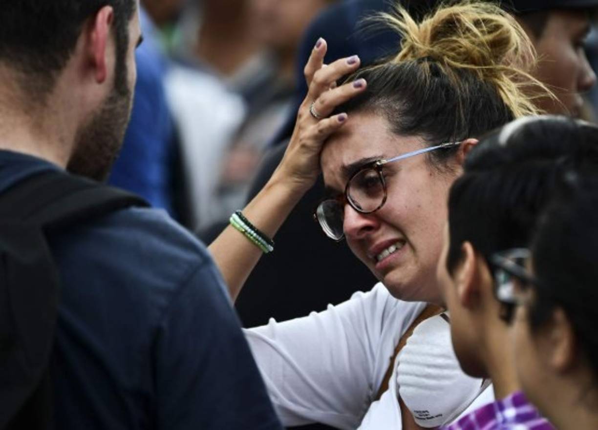 A distressed woman with a relative possibly buried under the rubble of a building knocked down by the powerful 7.1-magnitude quake on the eve, awaits for news from the rescue teams, in Mexico City, on September 20, 2017. <br/>At least 216 people were killed when a powerful 7.1-magnitude earthquake struck Mexico on Tuesday, including 21 children crushed beneath an elementary school that was reduced to rubble. / AFP PHOTO / RONALDO SCHEMIDT