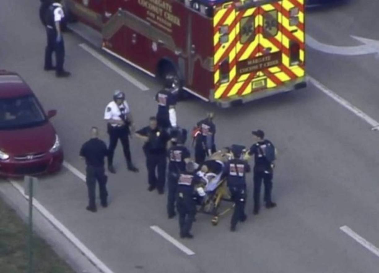 A woman places flowers beside a makeshift memorial outside the Cielo Vista Mall Wal-Mart (background) where a shooting left 20 people dead in El Paso, Texas, on August 4, 2019. - A shooting at a Walmart store in Texas left multiple people dead. At least one suspect was taken into custody after the shooting in the border city of El Paso, triggering fear and panic among weekend shoppers as well as widespread condemnation. It was the second fatal shooting in less than a week at a Walmart store in the US and comes after a mass shooting in California last weekend. (Photo by Mark RALSTON / AFP)