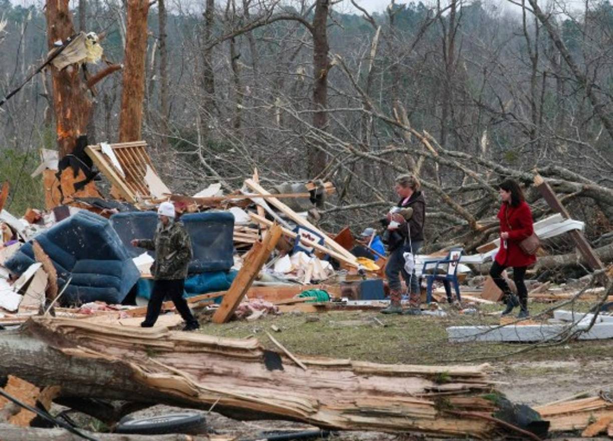 Residents look for belongings March 4, 2019 at a home after it was destroyed in a tornado in Beauregard, Alabama. - Rescuers in Alabama resumed search operations Monday after at least two tornadoes killed 23 people, uprooted trees and caused 'catastrophic' damage to buildings and roads in the southern US state. 'The devastation is incredible,' Lee County Sheriff Jay Jones told the local CBS affiliate late Sunday.'I cannot recall at least in the last 50 years... a situation where we have had this loss of life that we experienced today.' (Photo by Tami Chappell / AFP)