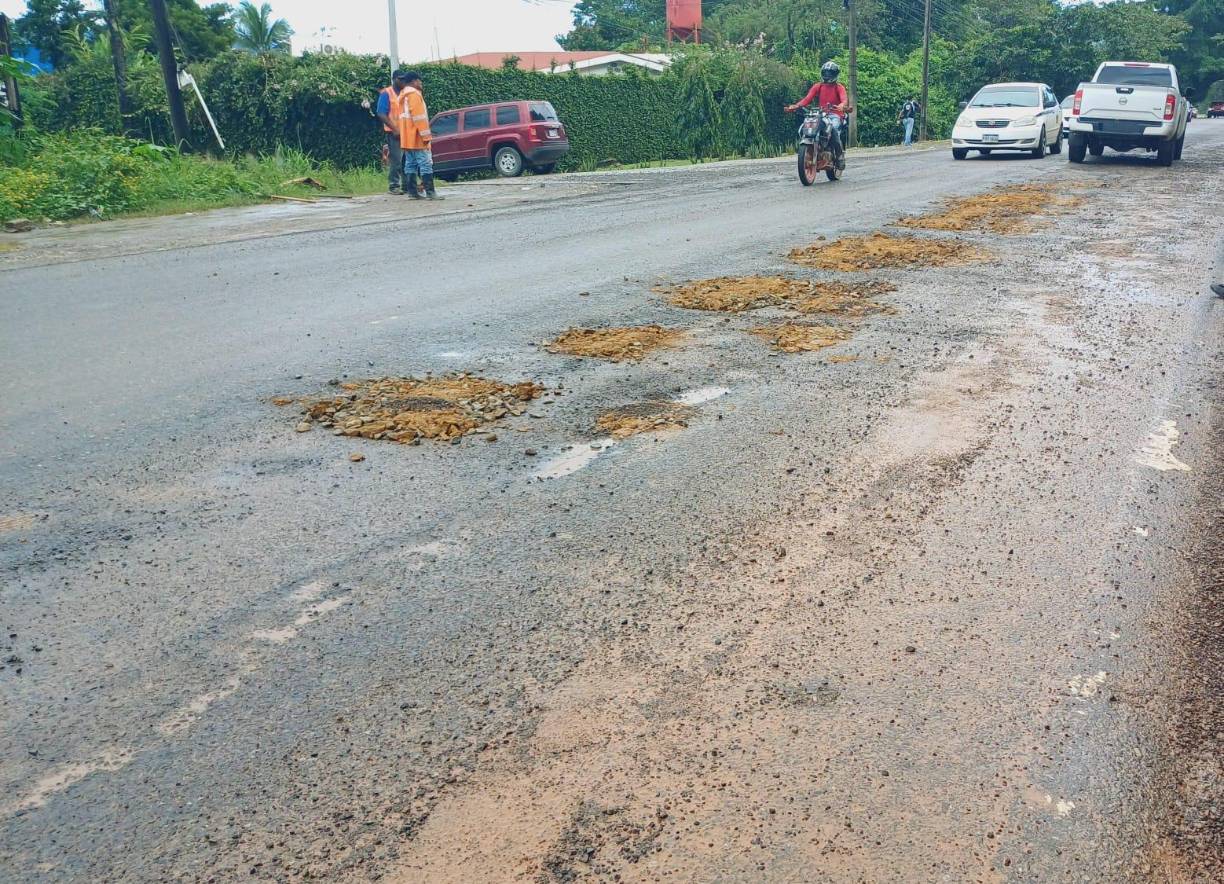Con tierra tapan algunos hoyos los ciudadanos, ante la desidia del Gobierno por reparar la carretera CA-13. 