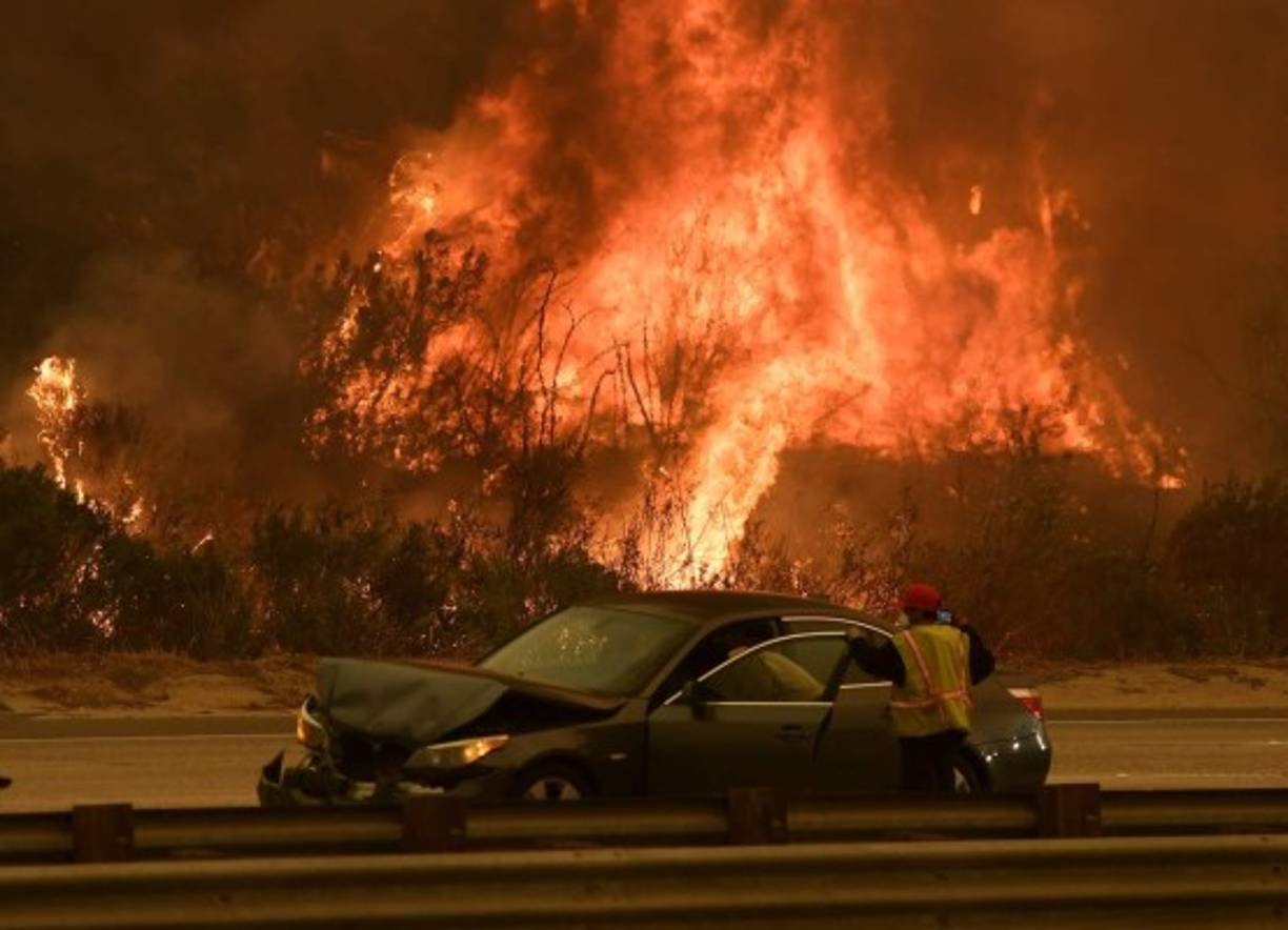 EUA. Evacuados más de 200,000 por incendios. <br/>Una mujer recibe auxilio en una autopista de Ventura, California, donde el incendio amenaza a unas 12,000 casas. El sur del estado en devastación.