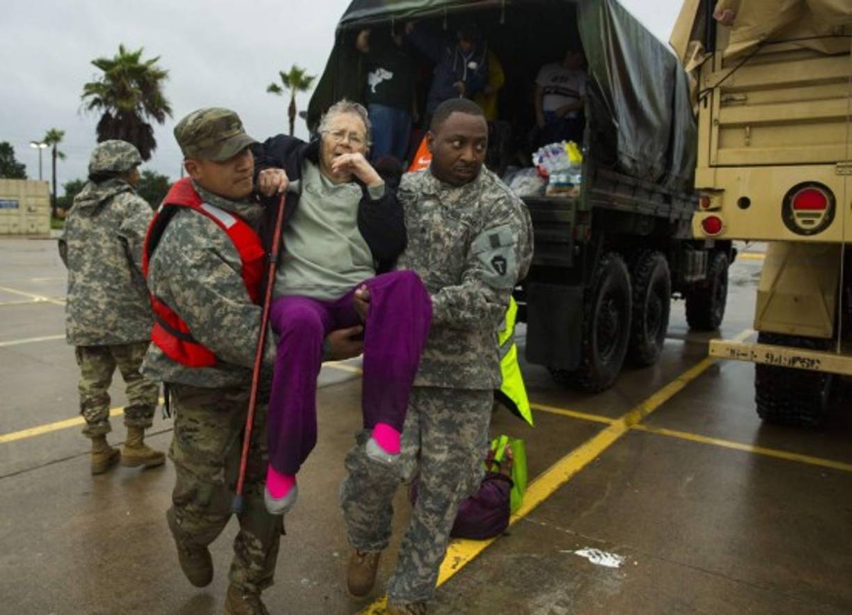 WESTLAKE, TX - AUGUST 29: Texas Army National Guard members Sergio Esquivel, left, and Ernest Barmore carry 81-year-old Ramona Bennett after she and other residents were rescued from their Pine Forest Village neighborhood due to high water from Hurricane Harvey August 29, 2017 in Houston, Texas. Harvey, which made landfall north of Corpus Christi late Friday evening, is expected to dump upwards to 40 inches of rain in areas of Texas over the next couple of days. Erich Schlegel/Getty Images/AFP<br/><br/>== FOR NEWSPAPERS, INTERNET, TELCOS & TELEVISION USE ONLY ==<br/><br/>