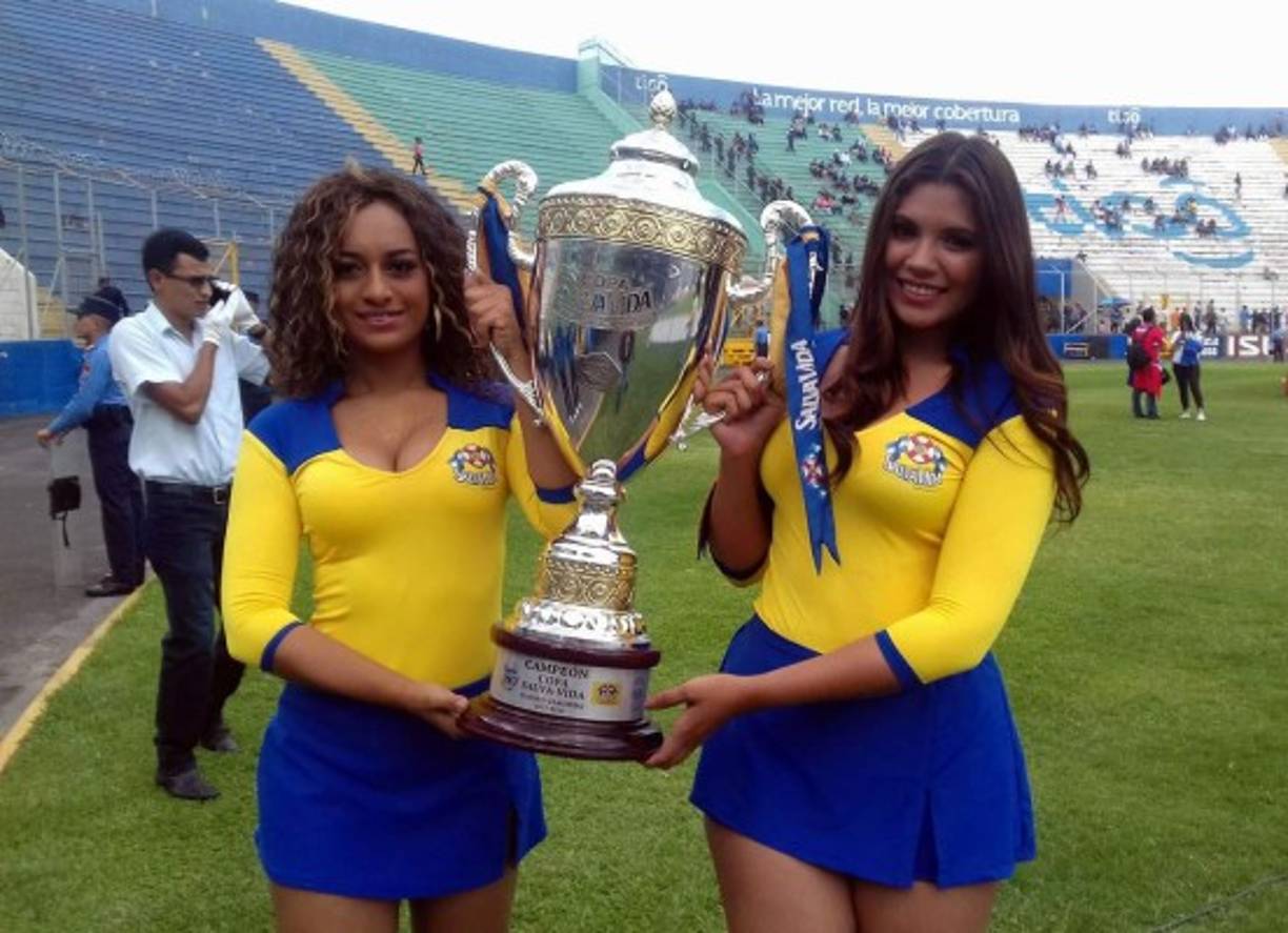 Las bellas edecanes que lucieron la copa que se llevará el campeón del torneo.