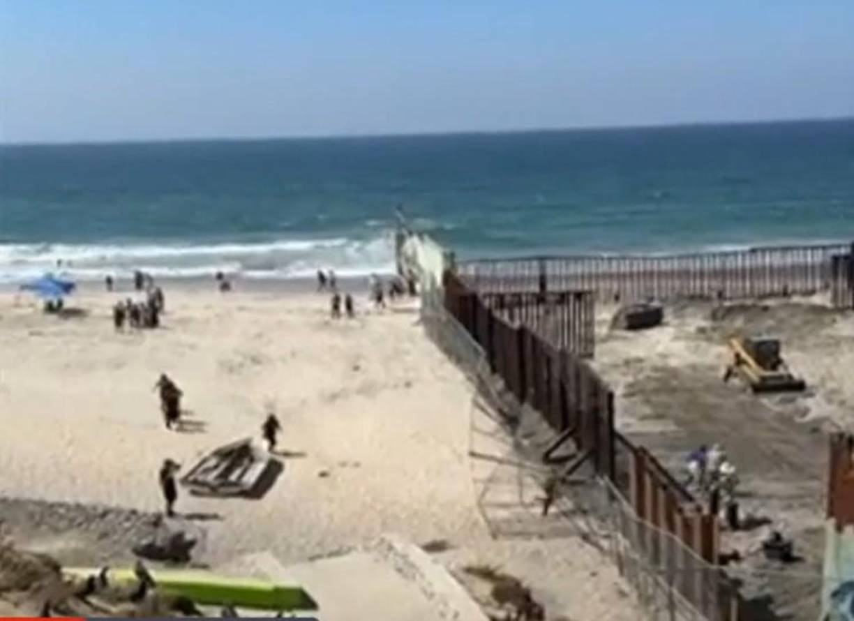 El grupo de personas que esperaban en las playas de Tijuana aprovechó que la malla metálica estaba caída para cruzar la frontera. 