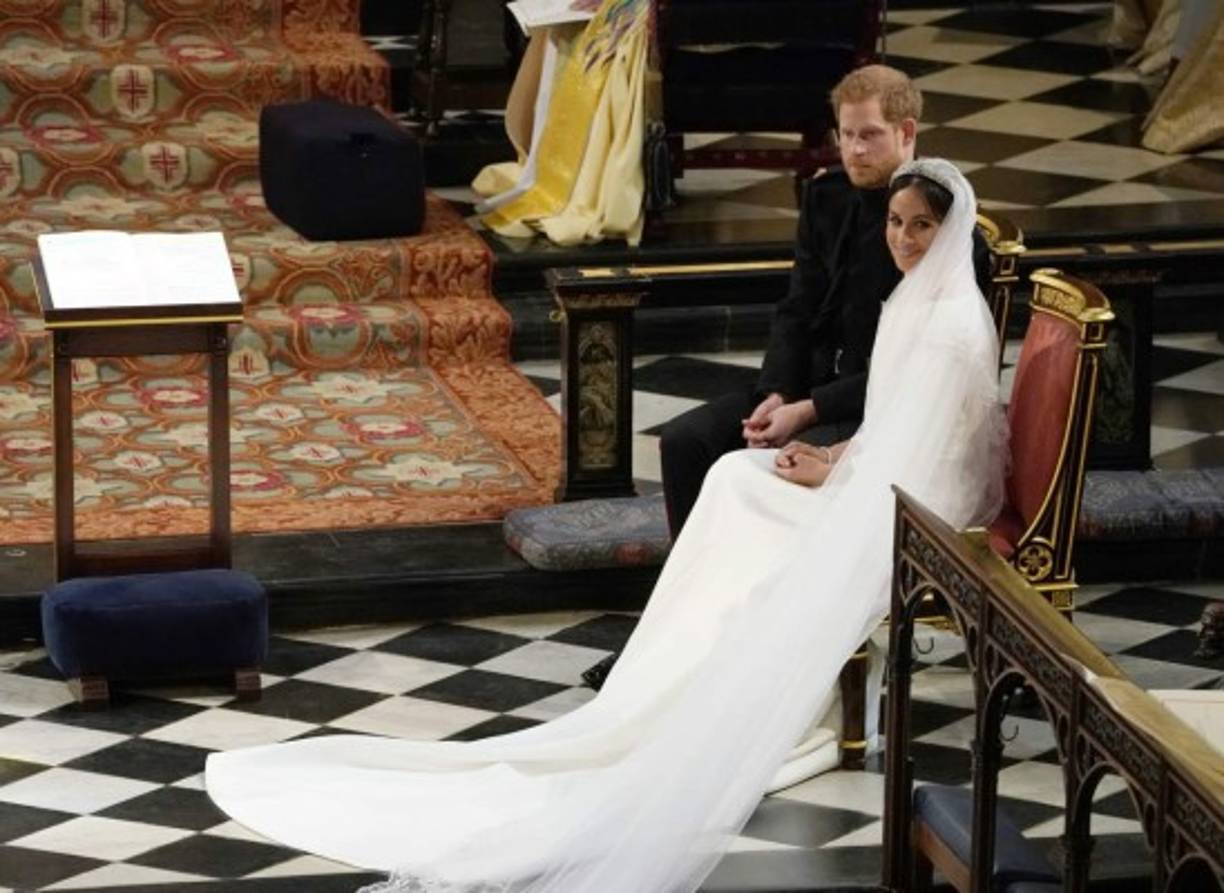 El príncipe Harry, Duque de Sussex (L) de Gran Bretaña se sienta con la actriz estadounidense Meghan Markle (R) durante la lectura en la Capilla de San Jorge, en Windsor Castle, en Windsor, durante su ceremonia de boda.<br/>Owen Humphreys / PISCINA / AFP