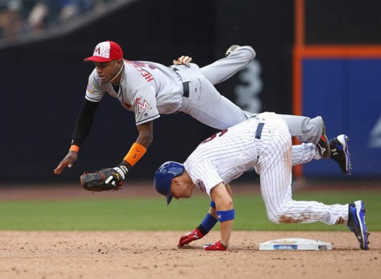 BÉISBOL. Al suelo por la base. Brandon Nimmo (abajo), de los Mets, está a salvo en la segunda base mientras cae en el campo corto frente a Adeiny Hechavarría, de los Marlins. Foto: AFP/Rich Schultz