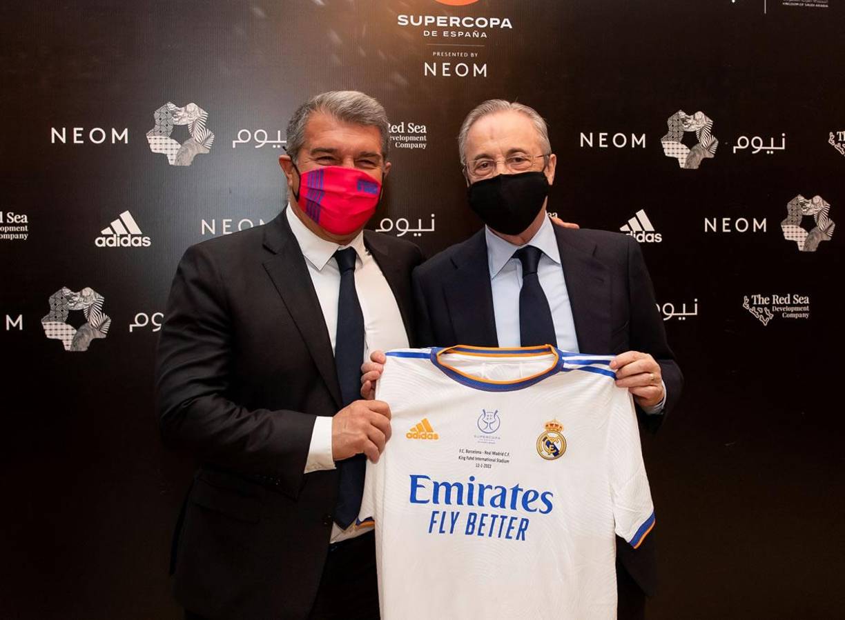Los presidentes del FC Barcelona, Joan Laporta, y del Real Madrid, Florentino Pérez, posan con una camiseta del equipo blanco en el descanso del clásico de la Supercopa de España.