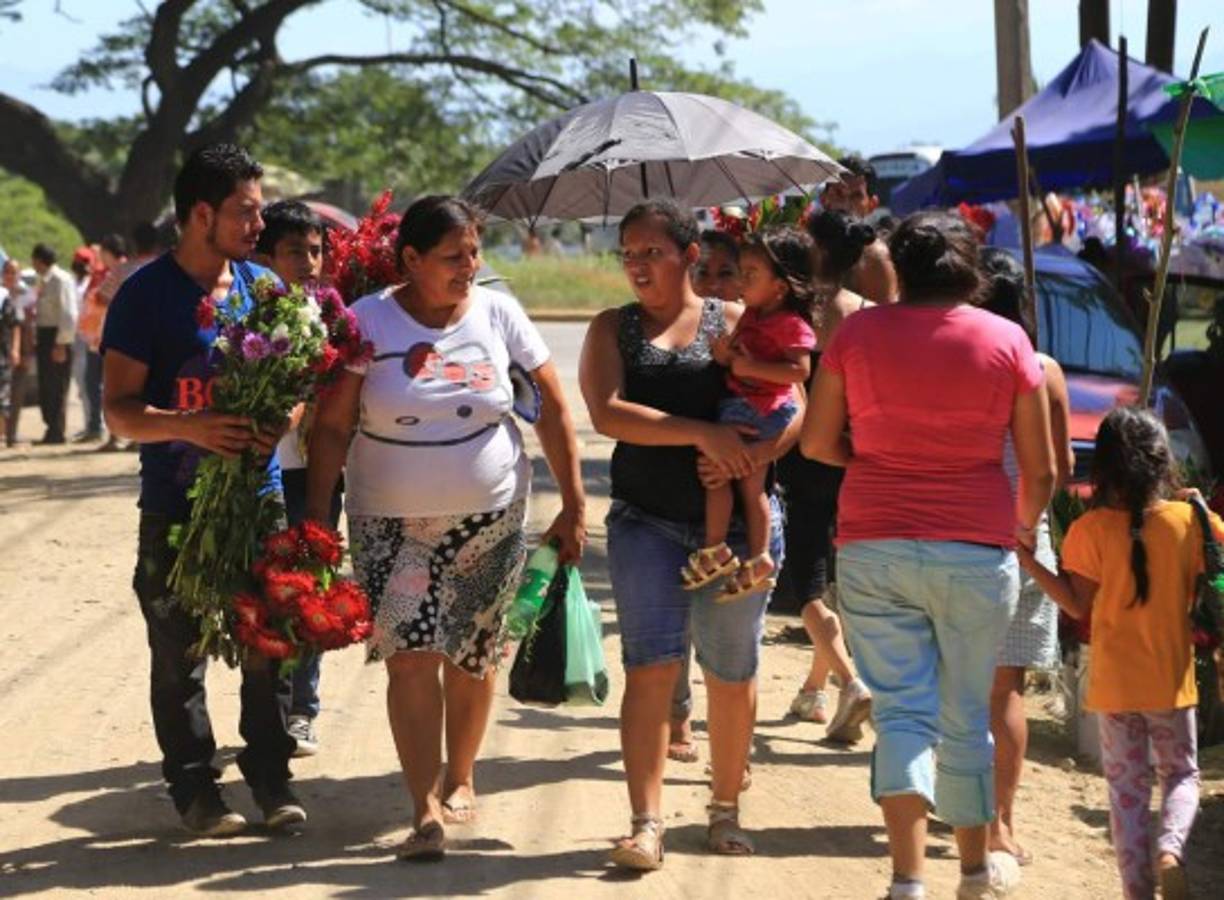 Los visitantes a los cementerios como La Puerta reciben las ofertas de los vendedores de flores y de recuerdos.