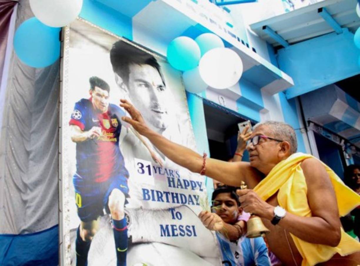 Un señor en la India observa una póster del ídolo argentino.