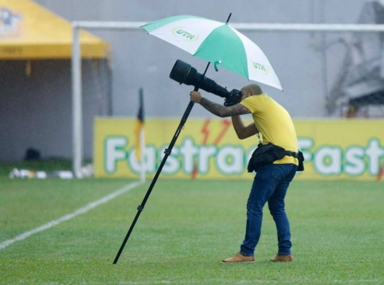 El fotógrafo de Diario La Prensa, Yoseph Amaya, realizando su trabajo y cubriéndose de la lluvia.