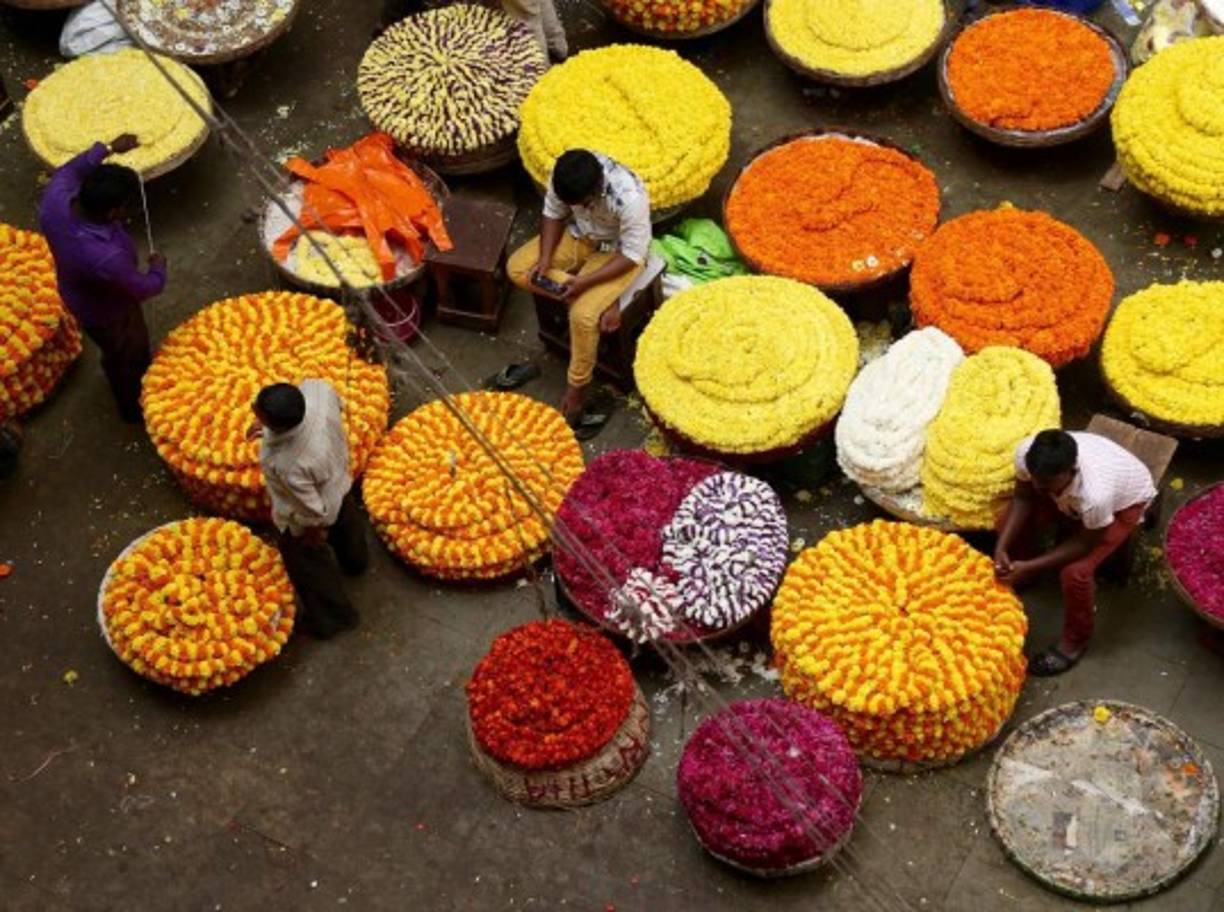 INDIA. Collage de flores. Vendedores de flores permanecen en su puesto en un mercado de Bangalore. Foto: EFE/Jagadeesh Nv