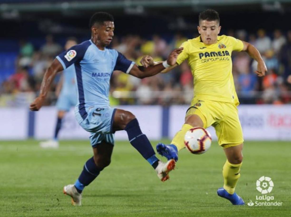 El delantero hondureño disputa el balón con Santiago Cáseres, mediocampista del Villarreal.