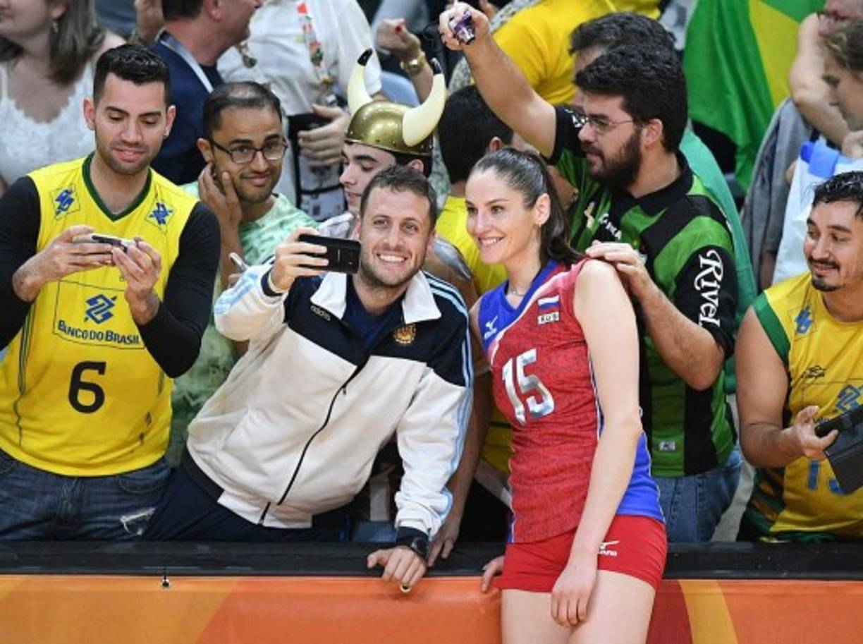 Los aficionados no pierden tiempo y se llevan el recuerdo de las bellas atletas. AFP.