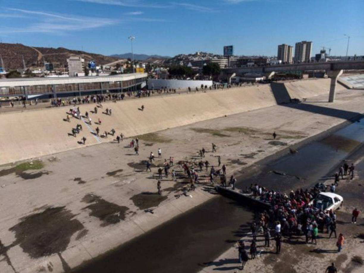 Cientos de migrantes consiguieron cruzar hasta un primero muro y trataron de cruzar el segundo, cubierto con púas, para lanzarse a Estados Unidos, donde agentes de la patrulla fronteriza se movilizaban.