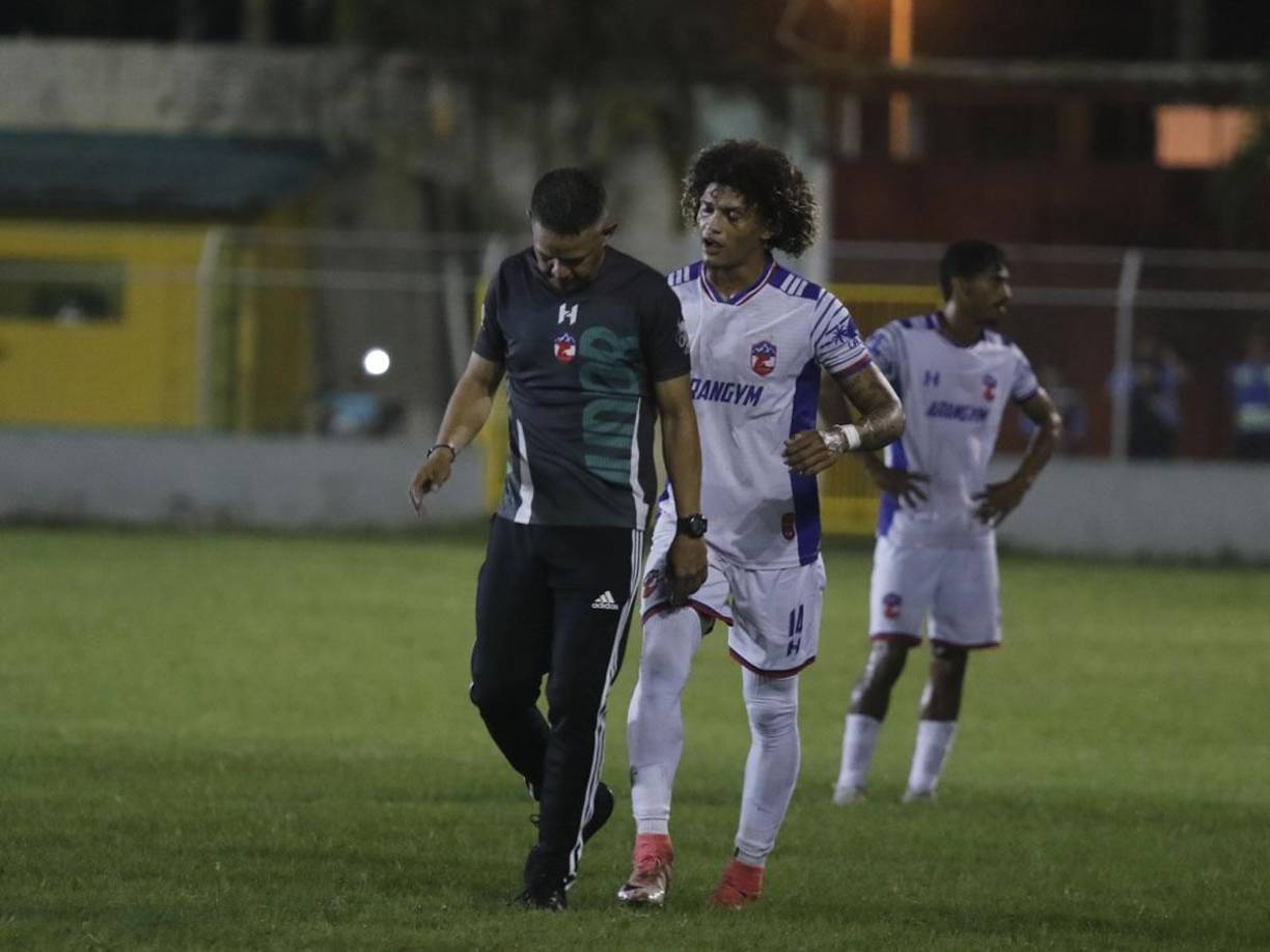 El miembro del cuerpo técnico del Atlético Júnior saliendo lentamente del campo de juego.