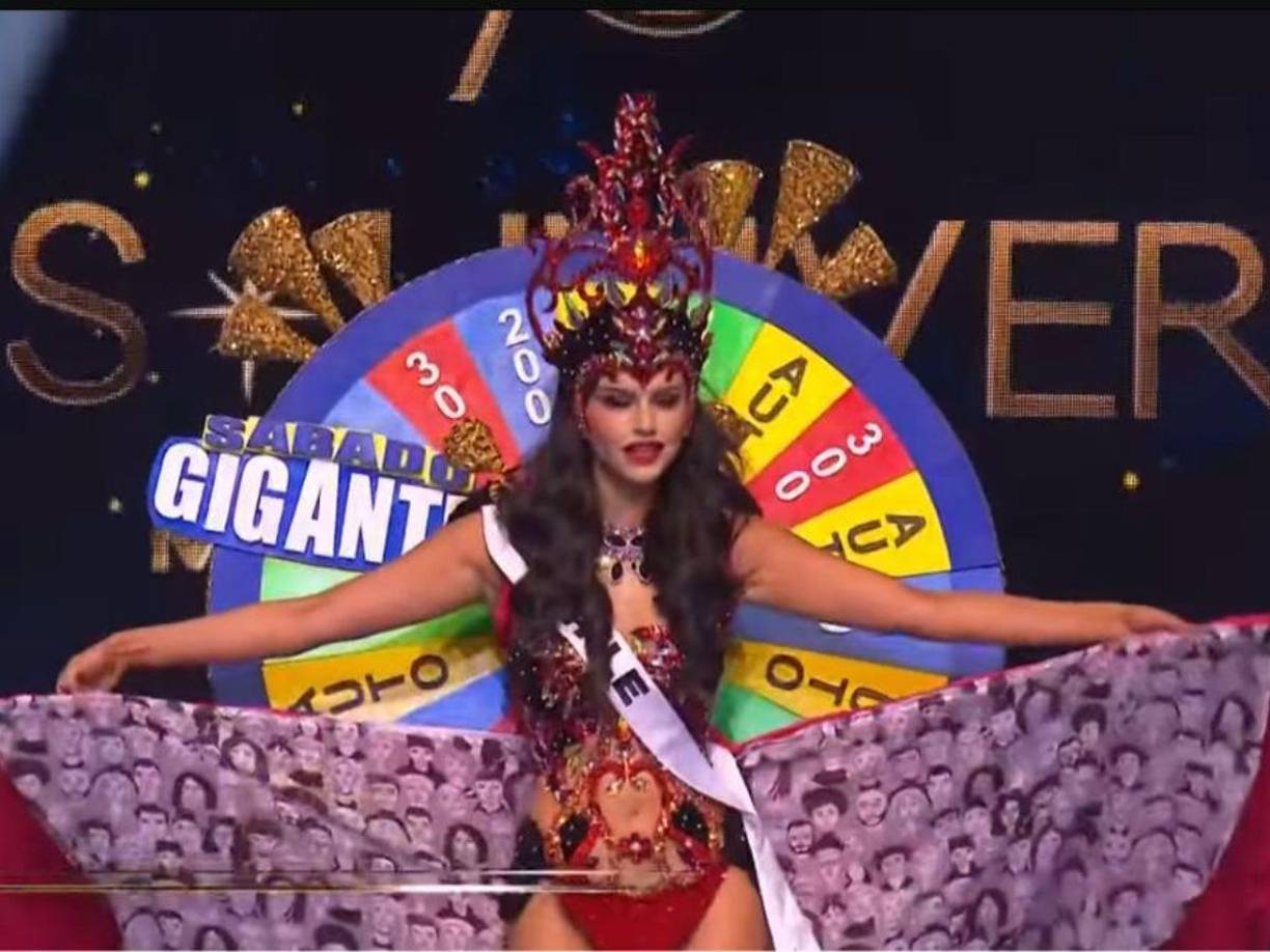 La representante de Chile apareció con un pequeño traje rojo, con botas doradas y una corona en su cabeza. Pero lo más destacado fue que en su espalda portaba una tómbola con la leyenda Sábado Gigante, como las que se solían utilizar en el popular programa de TV animado por Don Francisco. 