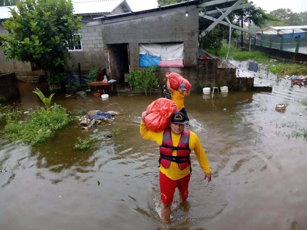 Los bomberos, en su trabajo de evacuación cargaron en en sus hombros las pertenencias de la anciana en la volqueta donde sería trasladada al albergue. 