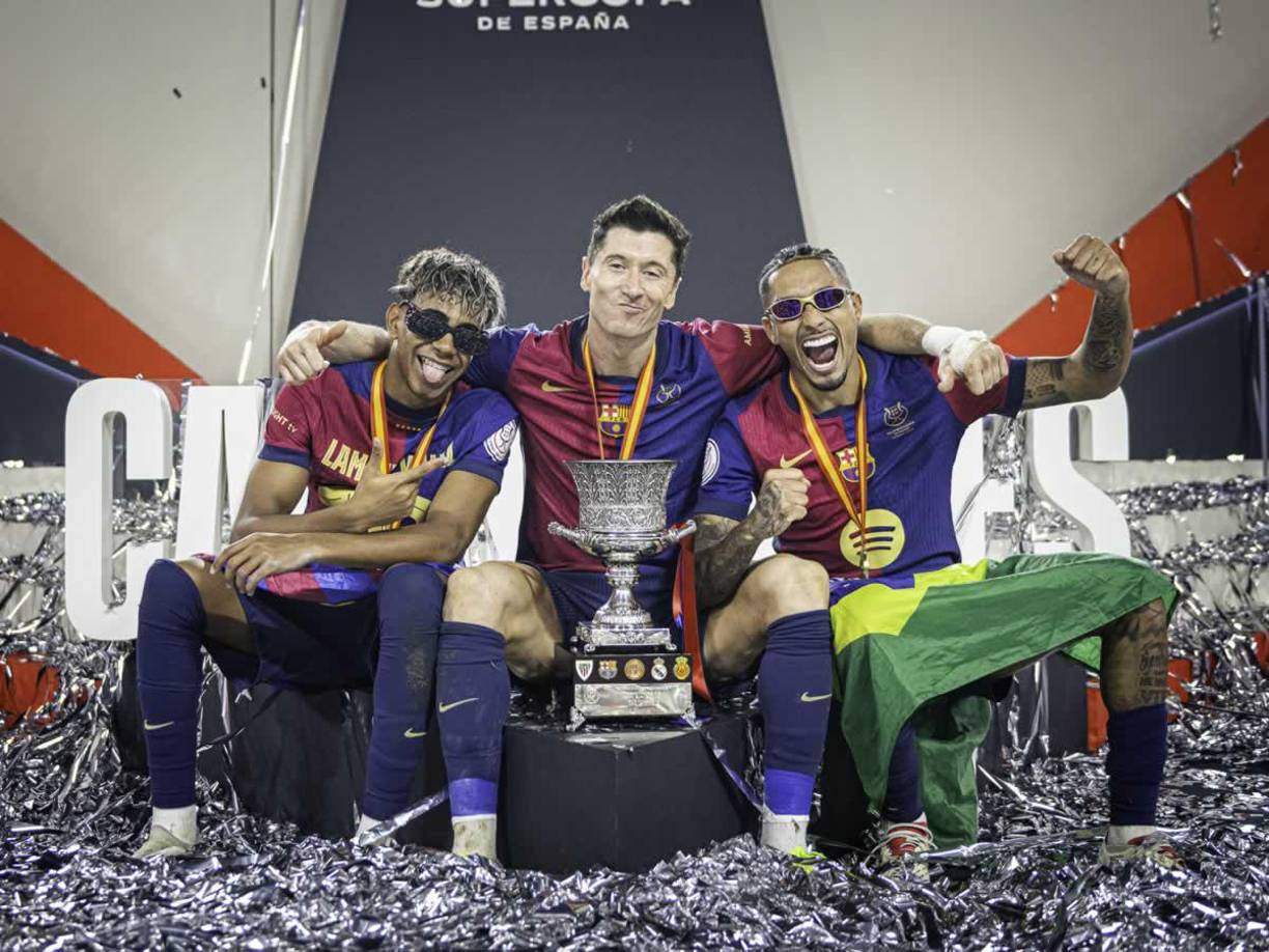 Lamine Yamal, Robert Lewandowski y Raphinha, posando con el trofeo de campeones de la Supercopa de España.