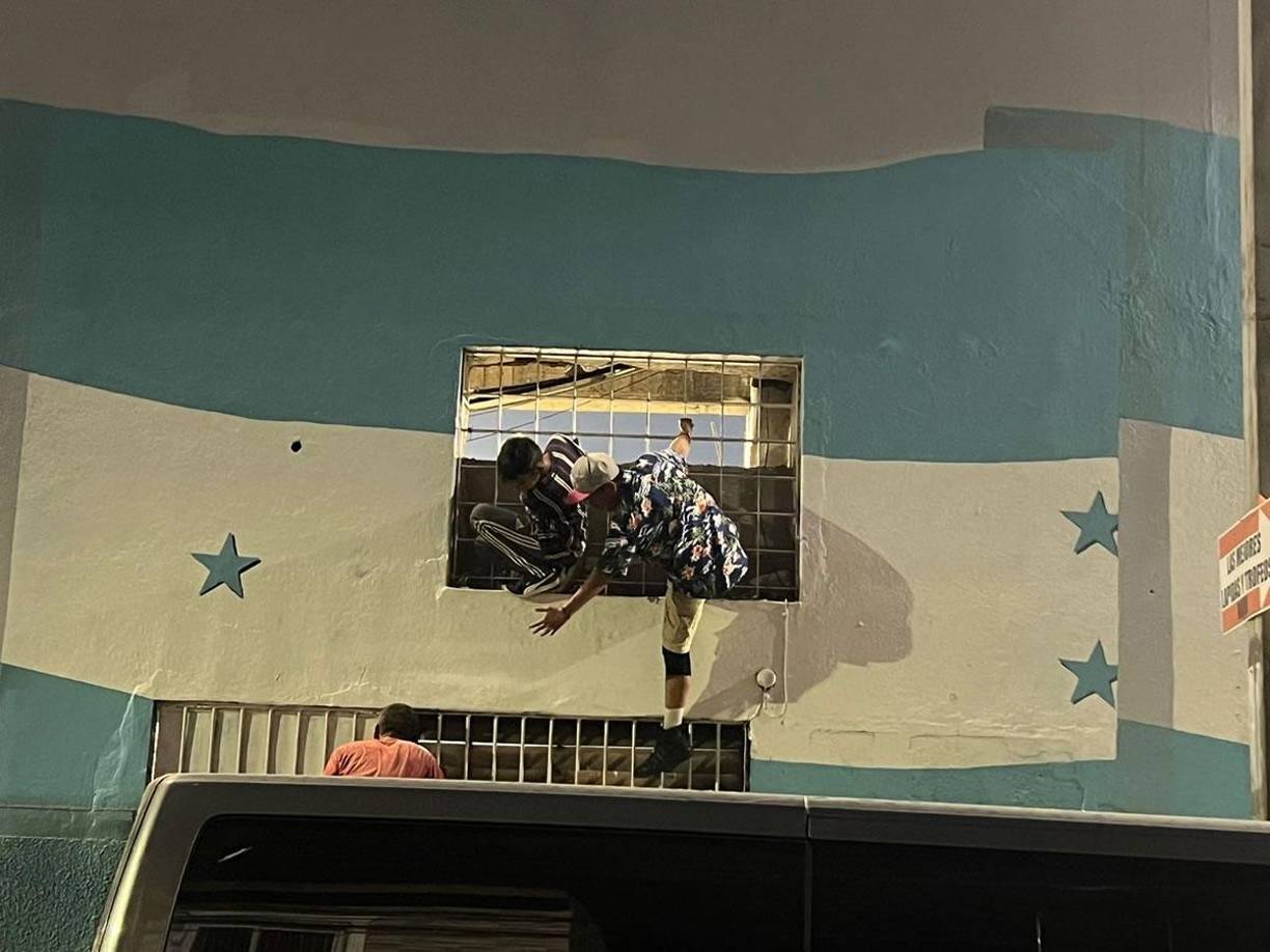 Aficionados que no pudieron ingresar al estadio estadio Nacional Chelato Uclés observan el partido entre Olimpia y Marathón desde las ventanas enrejadas del área en construcción del coloso capitalino.