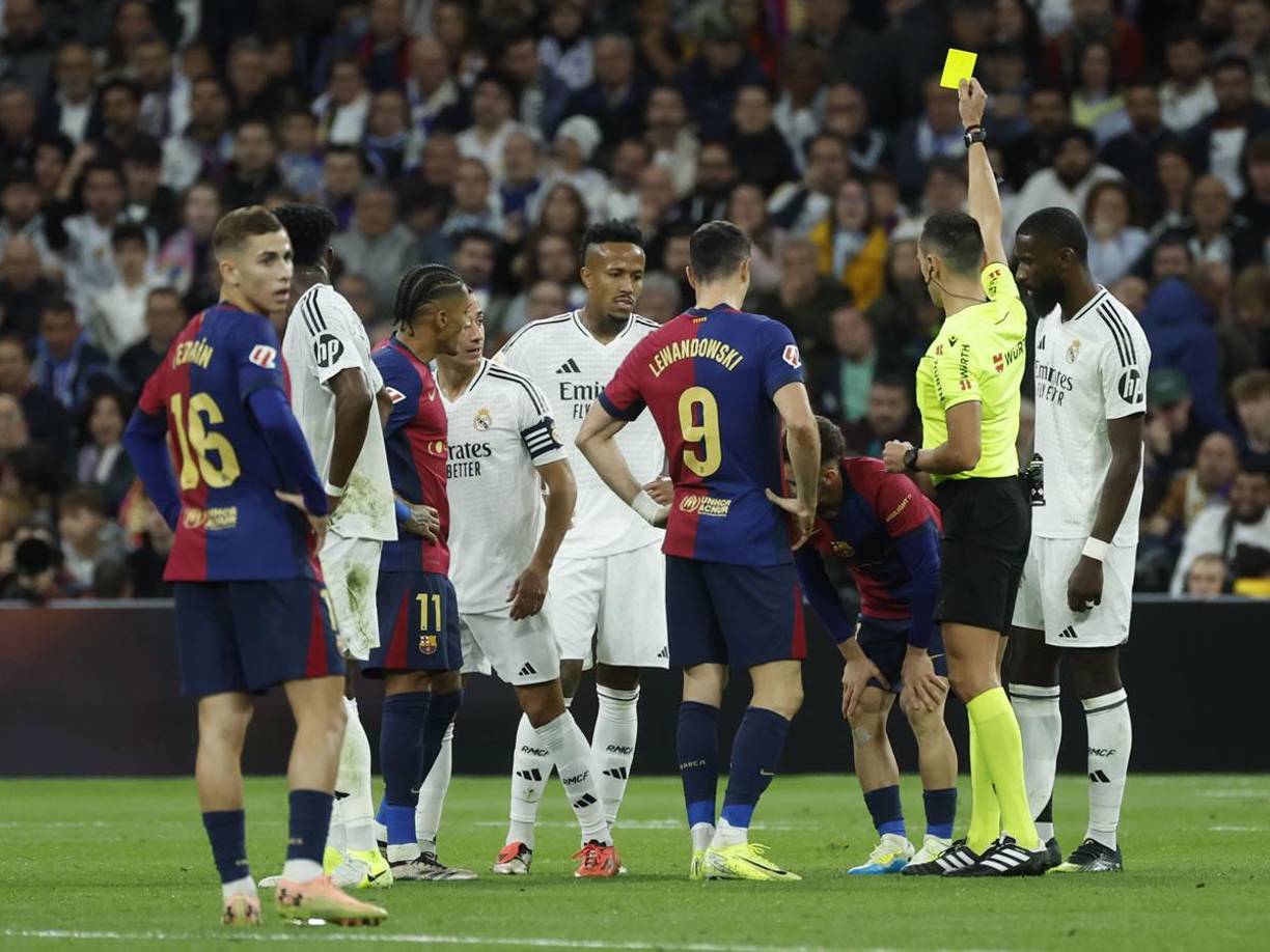 El árbitro le muestra la tarjeta amarilla a Marc Casadó por su falta contra Vinicius.