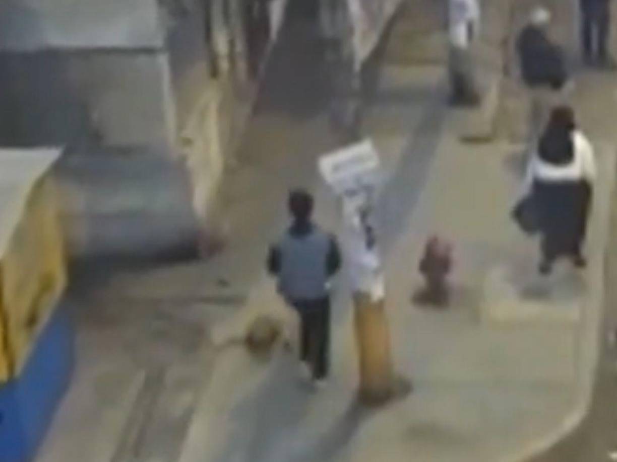 Antes de ingresar adonde intentaba asaltar aparece con otra vestimenta negra con una chaqueta gris y se pone una gorra.