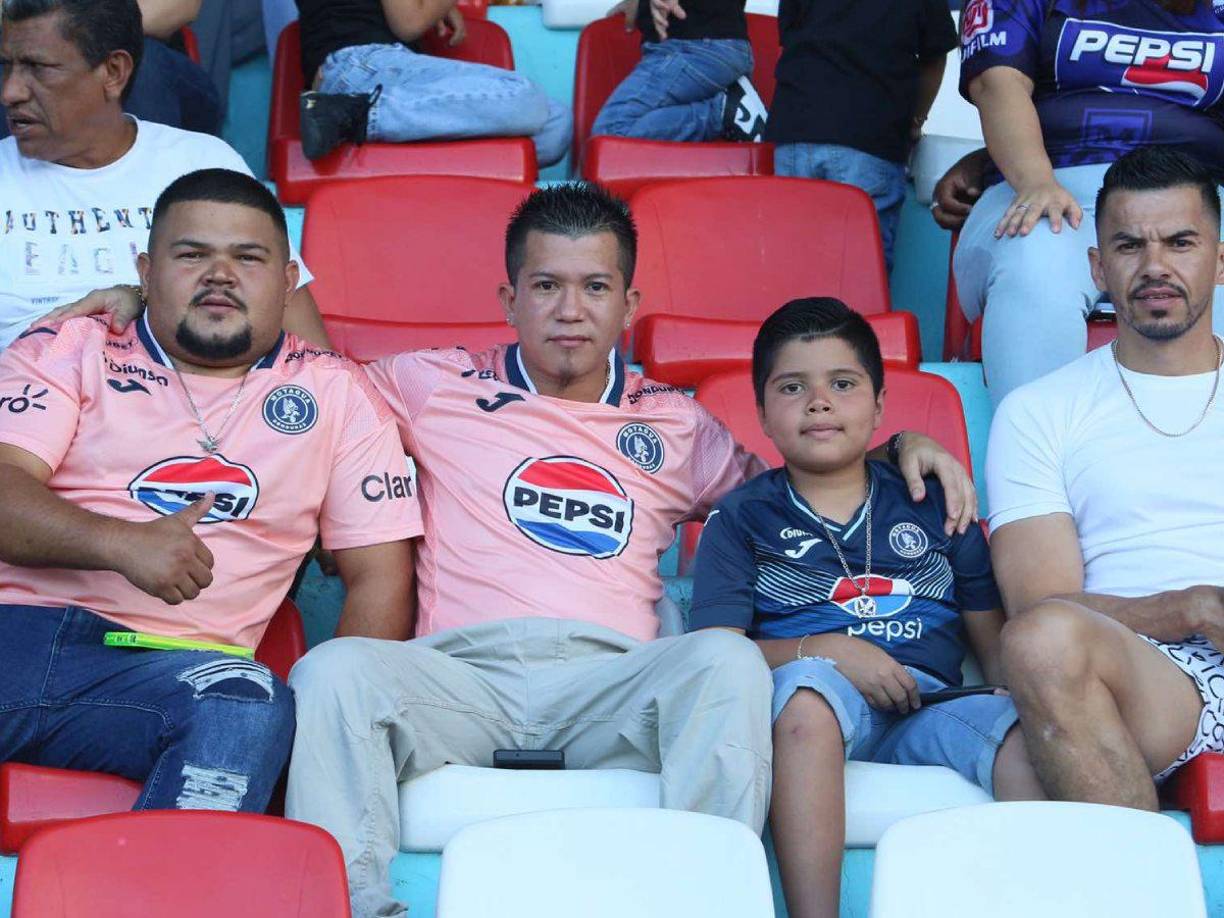 Tres aficionados del Motagua junto a un pequeño en el sector de silla. 