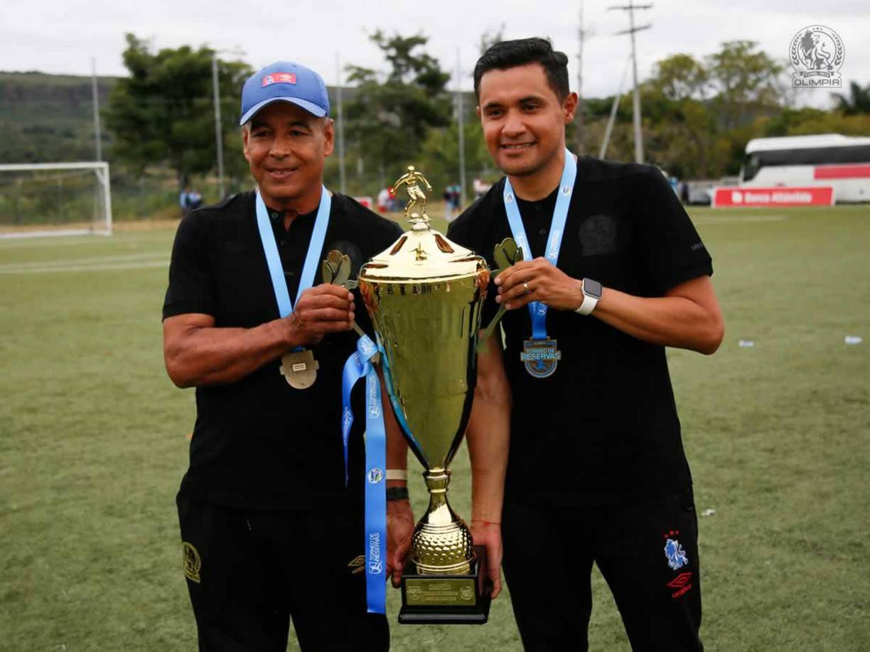 Juan Flores y su asistente Roger Rojas posando con el trofeo de campeones del Torneo de Reservas.